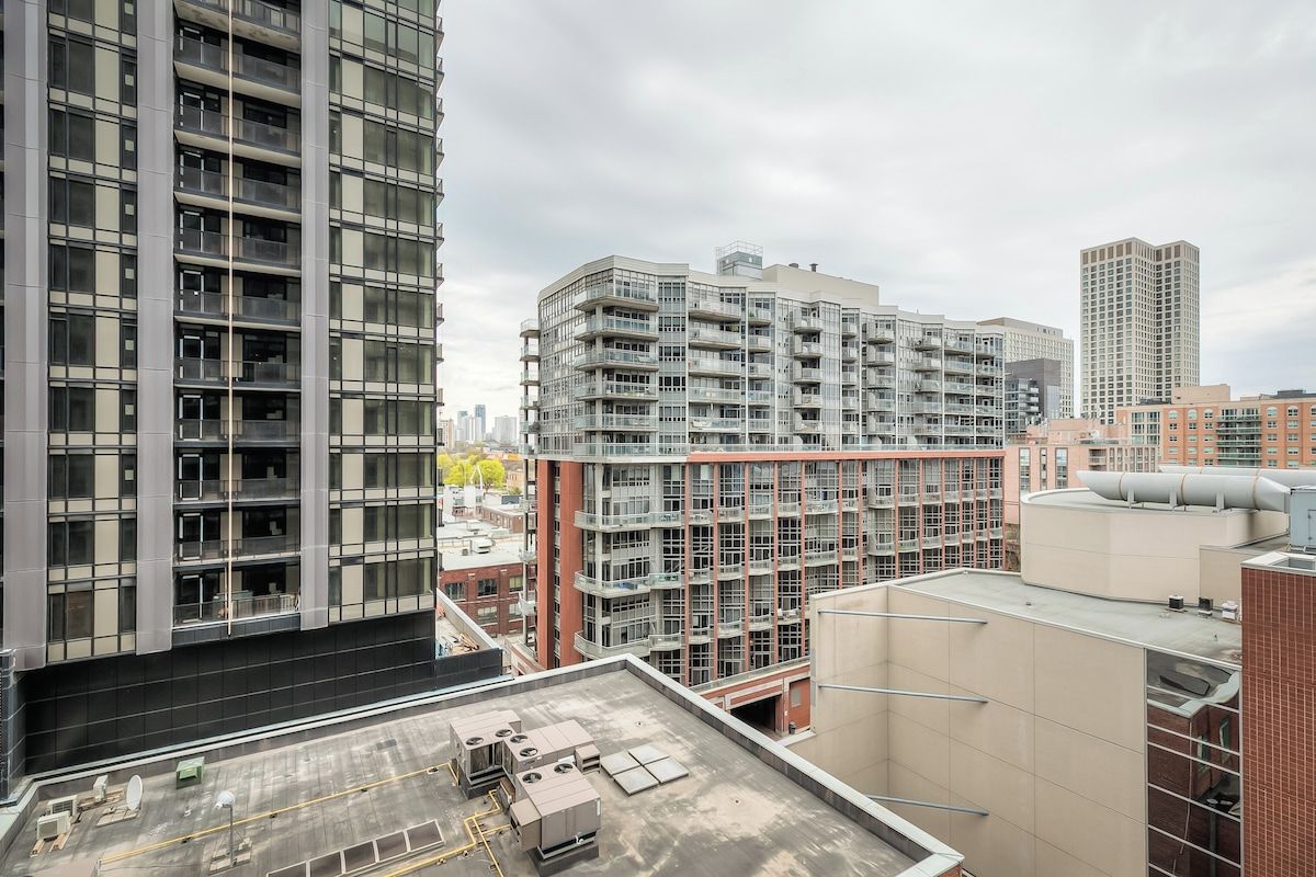 Un edificio de gran altura con varios pisos, amplias ventanas y una terraza plana en la azotea.