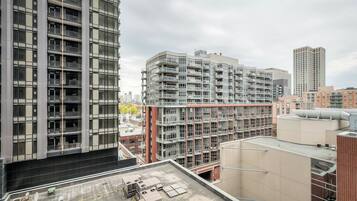 Un edificio de gran altura con varios pisos, amplias ventanas y una terraza plana en la azotea.