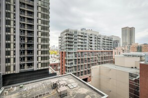 Un edificio de gran altura con varios pisos, amplias ventanas y una terraza plana en la azotea.