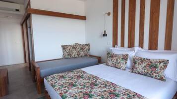 Un dormitorio con cama, un banco y una lámpara fijada a la pared.