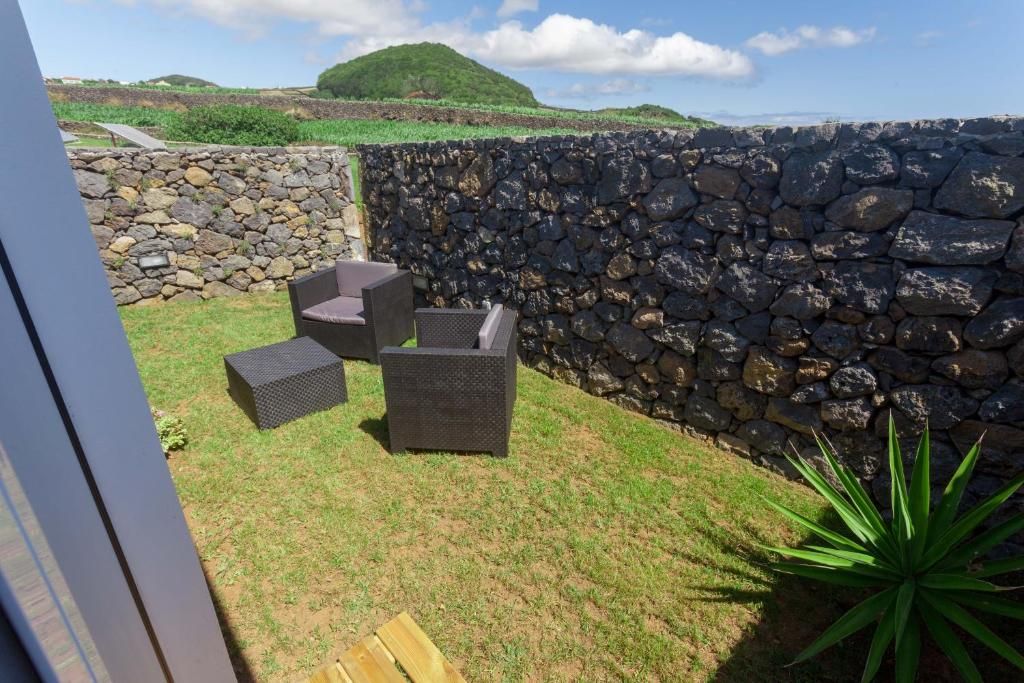 Un área de estar al aire libre con muros de piedra y vistas a las colinas.