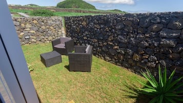 Un área de estar al aire libre con muros de piedra y vistas a las colinas.