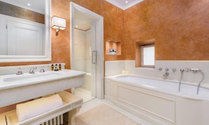 Ein Badezimmer mit einem Doppelwaschbecken, einer Badewanne und einem Spiegel.