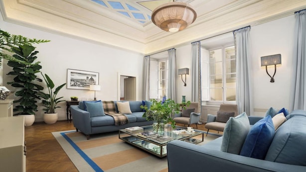 A spacious living room with a large sofa set, a coffee table, and a large plant. - GRAND FLORENTINE APARTMENT WITH FRESCOED CEILINGS NEAR THE UFFIZI (Firenze)