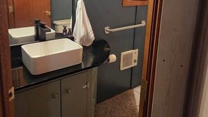 A bathroom with a vanity, sink, mirror, towel, and a shower curtain. - The Nelson 2, Winner (Winner)