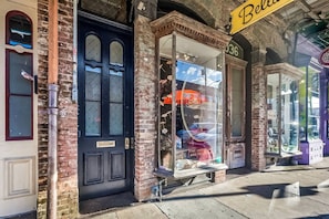 A storefront with a black door and a window display featuring umbrellas. - Casabianca: Elegant Flat in Historic Magazine Row (New Orleans)