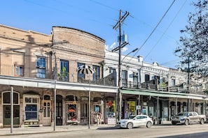 A multi-story building with a ground-level storefront and upper-story balconies. - Casabianca: Elegant Flat in Historic Magazine Row (New Orleans)