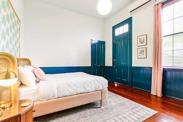 Een slaapkamer met een bed, nachtkastje en een raam met gordijnen.