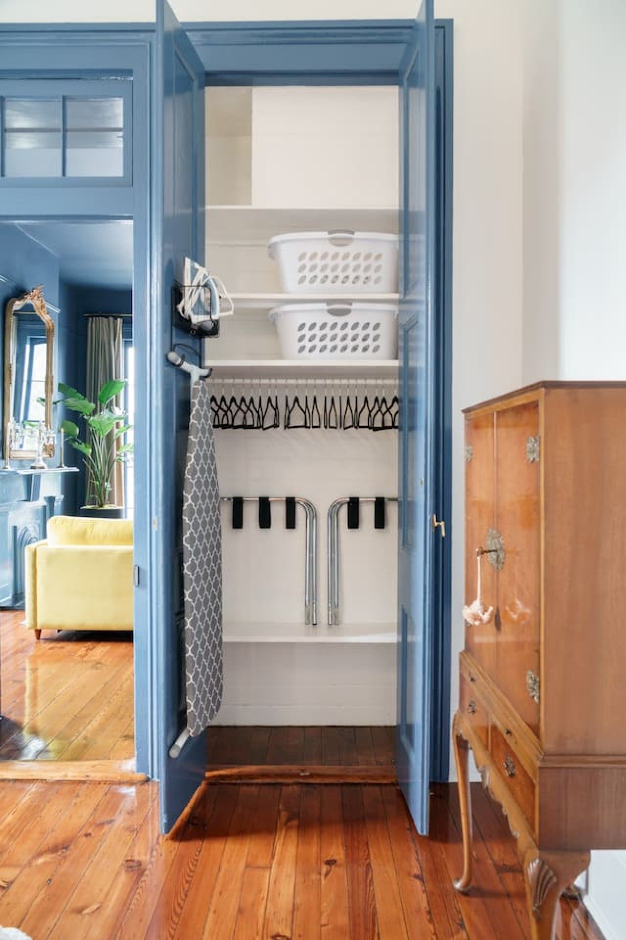 Ein helles Badezimmer mit Holzboden, einer weißen Badewanne, einem Handtuchhalter und einem Holzschrank.