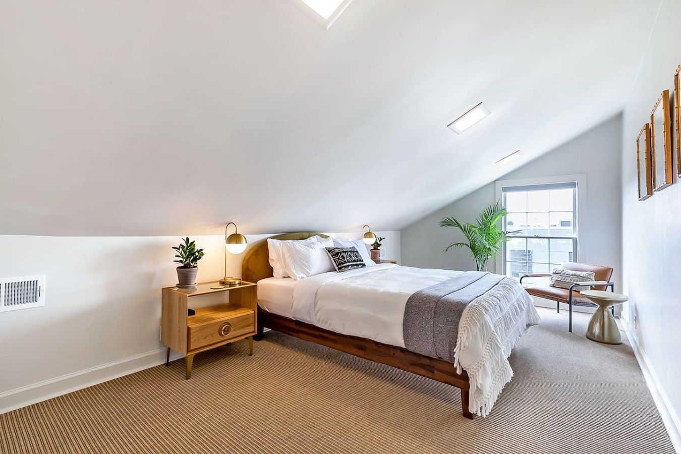 A bedroom with a bed, bedside tables, a lamp, a chair, and a window.