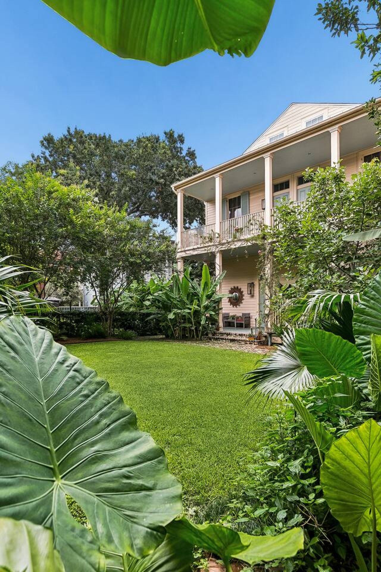 A two-story building with a covered porch and a well-maintained lawn.