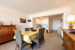 A dining area with a table, chairs, and a wooden cabinet. - Apartment Near Blankenberge Beach & Casino (Blankenberge)