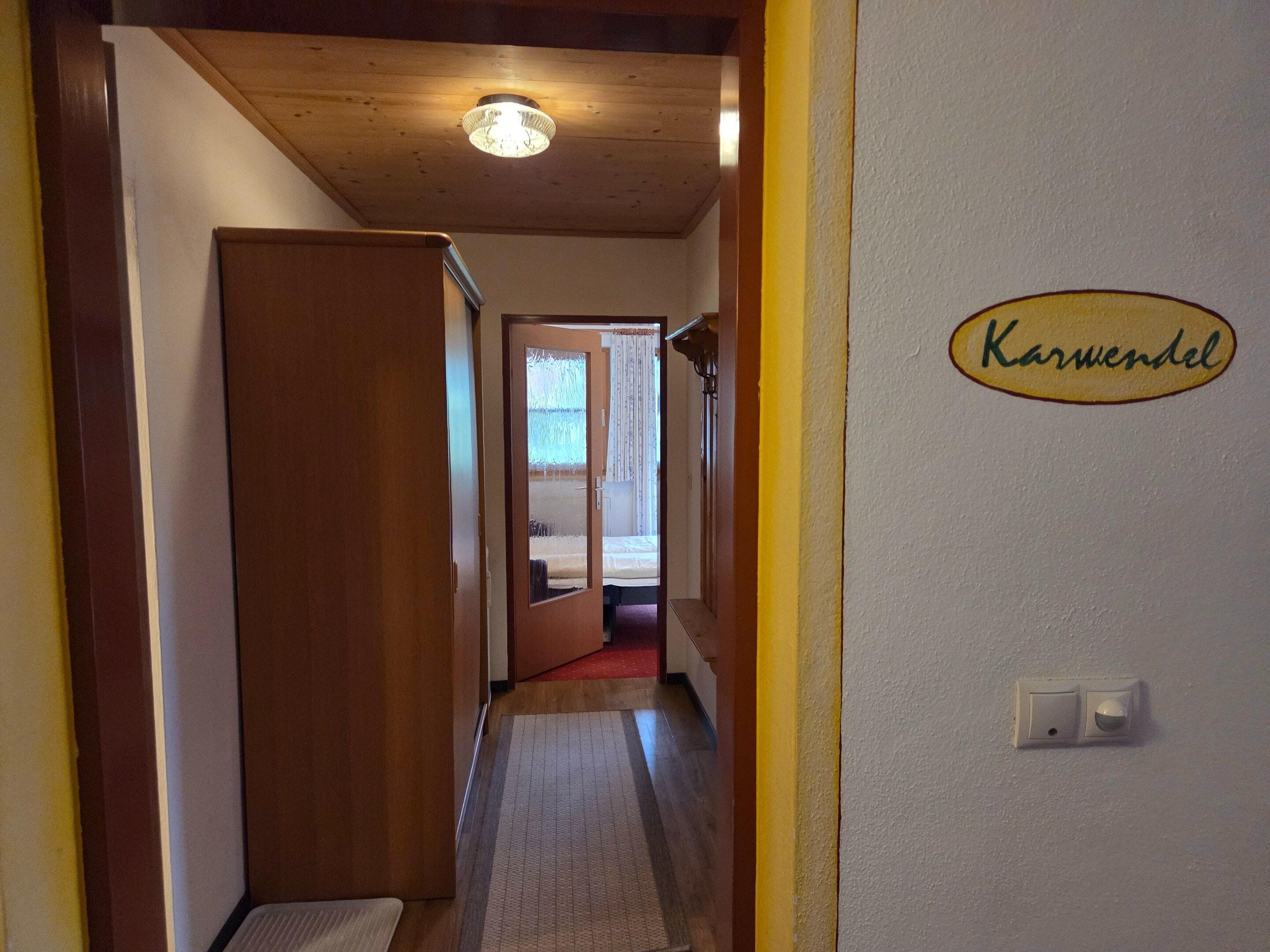 Ein Flur mit einer Holztür, Teppichboden und einer Wand mit Namensschild.
