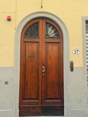 A double wooden door with a glass panel and a number '27' on the wall. - PORCELAIN FLORENCE APARTMENT (Firenze)
