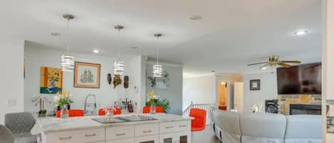 An open kitchen with a central island opens directly into the adjacent living room.