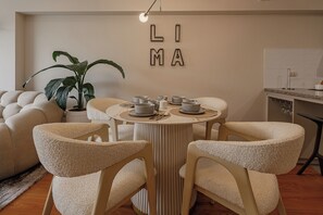 A dining area with a round table, four chairs, and a potted plant. - Vrbo Property (Miraflores)