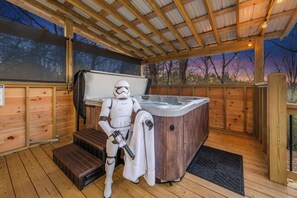 A wooden deck with a hot tub and a Star Wars character. - 3-bedroom house in perfect Ellijay with cool mountain vibes and wildlife (Ellijay)