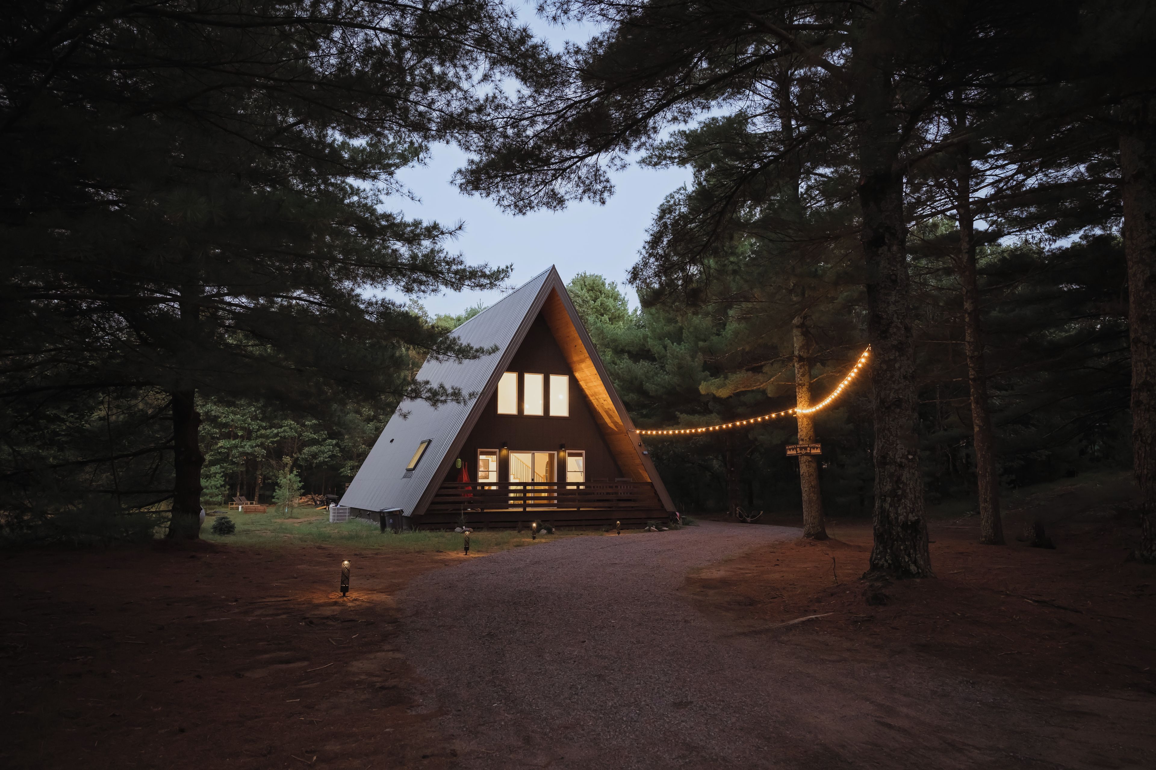 A cabin with a sloped roof, large windows, and a porch.