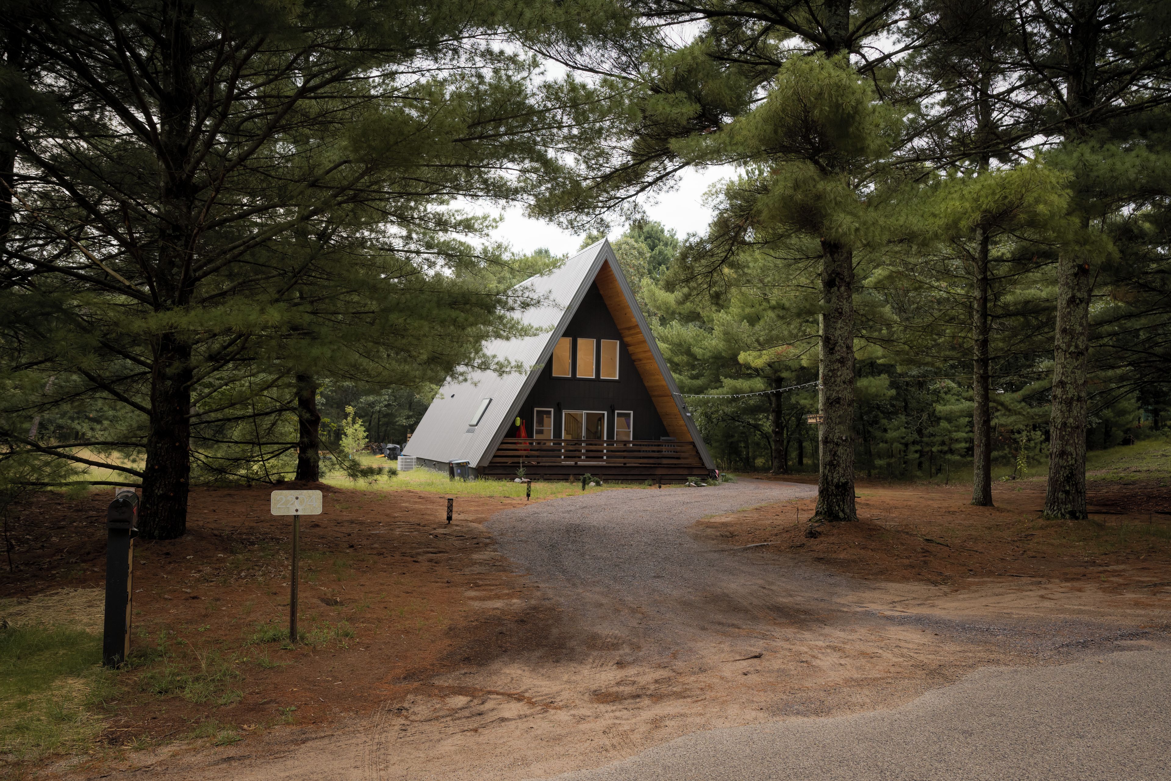 A cabin with a sloped roof, surrounded by trees.