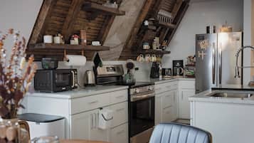 Een moderne keuken met een ingebouwde oven, magnetron en een roestvrijstalen koelkast.