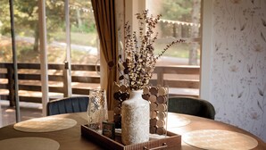 A round table with a vase of dried flowers, a glass vase, and a wooden tray. - Cozy A-frame w/HOT TUB, 5min walk to lake, King Bed, 30 min to Dells (Friendship)