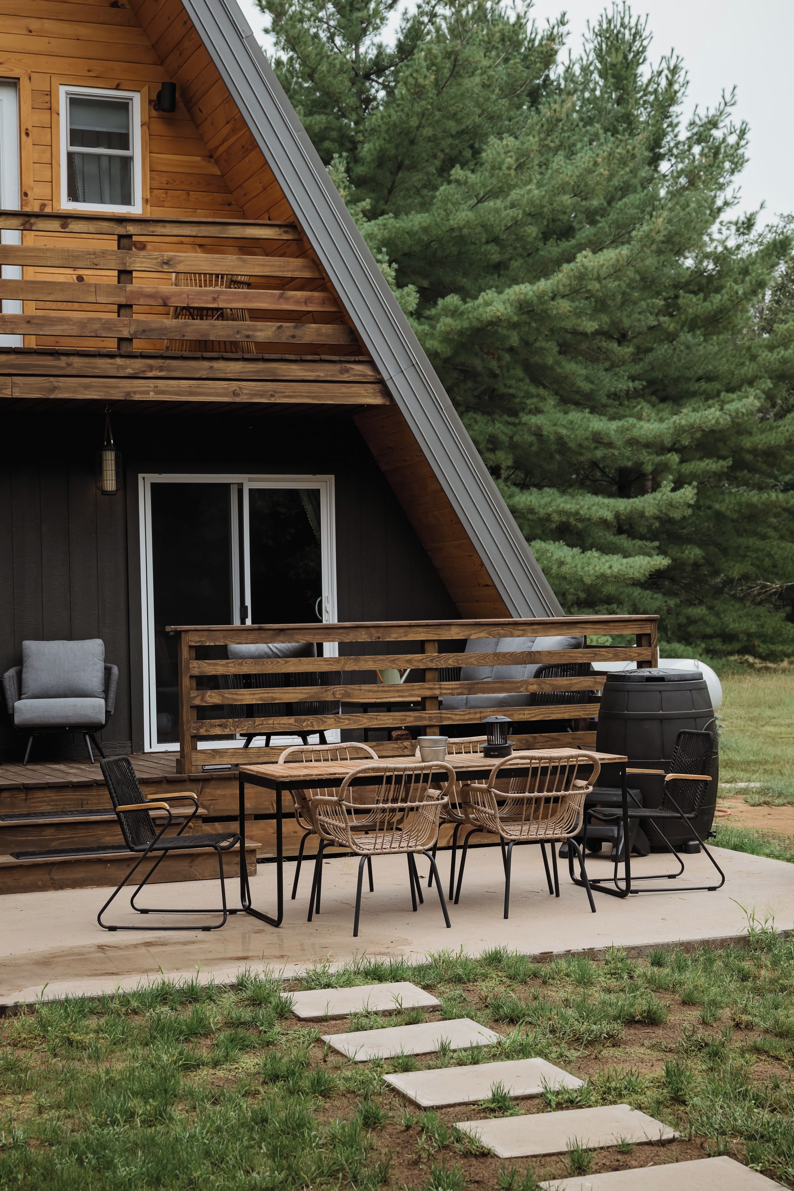 A wooden deck with outdoor furniture and a barbecue grill.