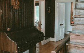 Une pièce avec une grille en bois, une porte blanche et un escalier.