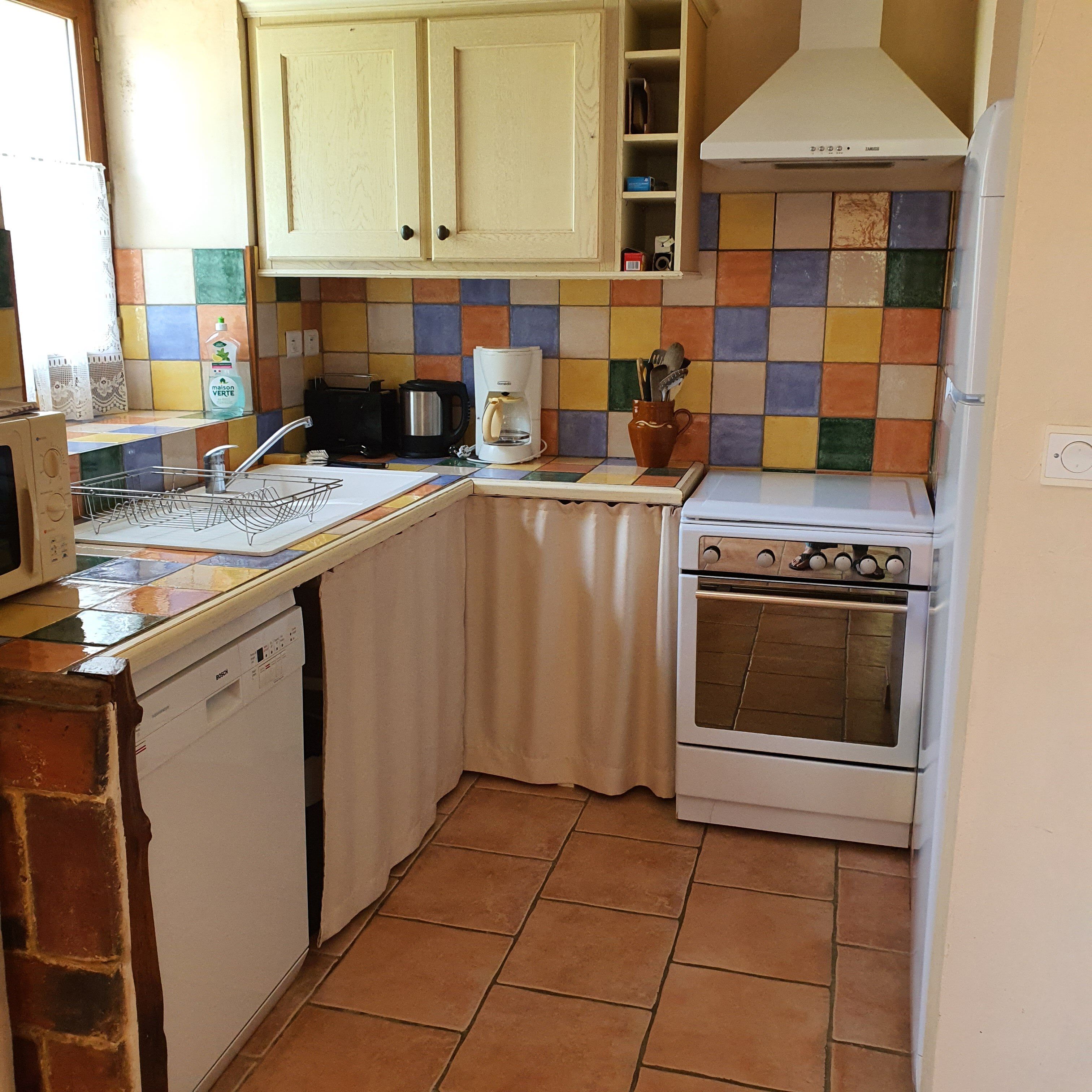 A kitchen with a Bosch dishwasher, a coffee maker, and a stove.