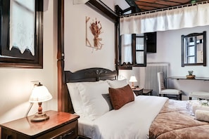 A hotel room with a bed, bedside tables, a lamp, a chair, a radiator, and a mirror. - "Naida Superior Double" Room with Mountain View, Balcony, and Fireplace (Μακρινίτσα)