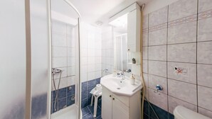 Un baño con ducha, lavamanos e inodoro.