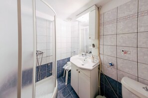 Ein Badezimmer mit Dusche, Waschbecken und Toilette.