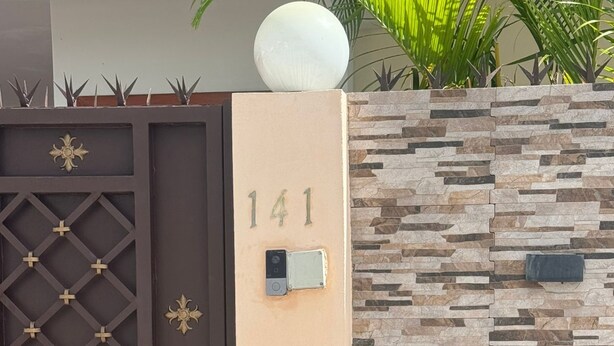 A modern building entrance with a numbered gate, decorative metalwork, and a textured stone wall. - Welcome to Villa Sol y Mar, an ideal place for families and couples. (La romana)