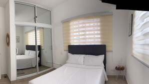 A bedroom with a bed, a wardrobe, and a window with blinds. - Welcome to Villa Sol y Mar, an ideal place for families and couples. (La romana)
