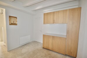 A room with a white wardrobe, a door, and a tiled floor. - Écrin Nature in Guéthary - Pool & Petanque (Guéthary)