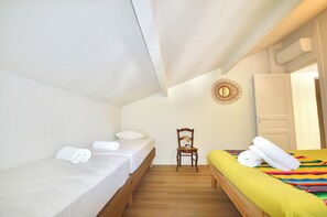 A bedroom with two beds, a chair, and a door. - Écrin Nature in Guéthary - Pool & Petanque (Guéthary)