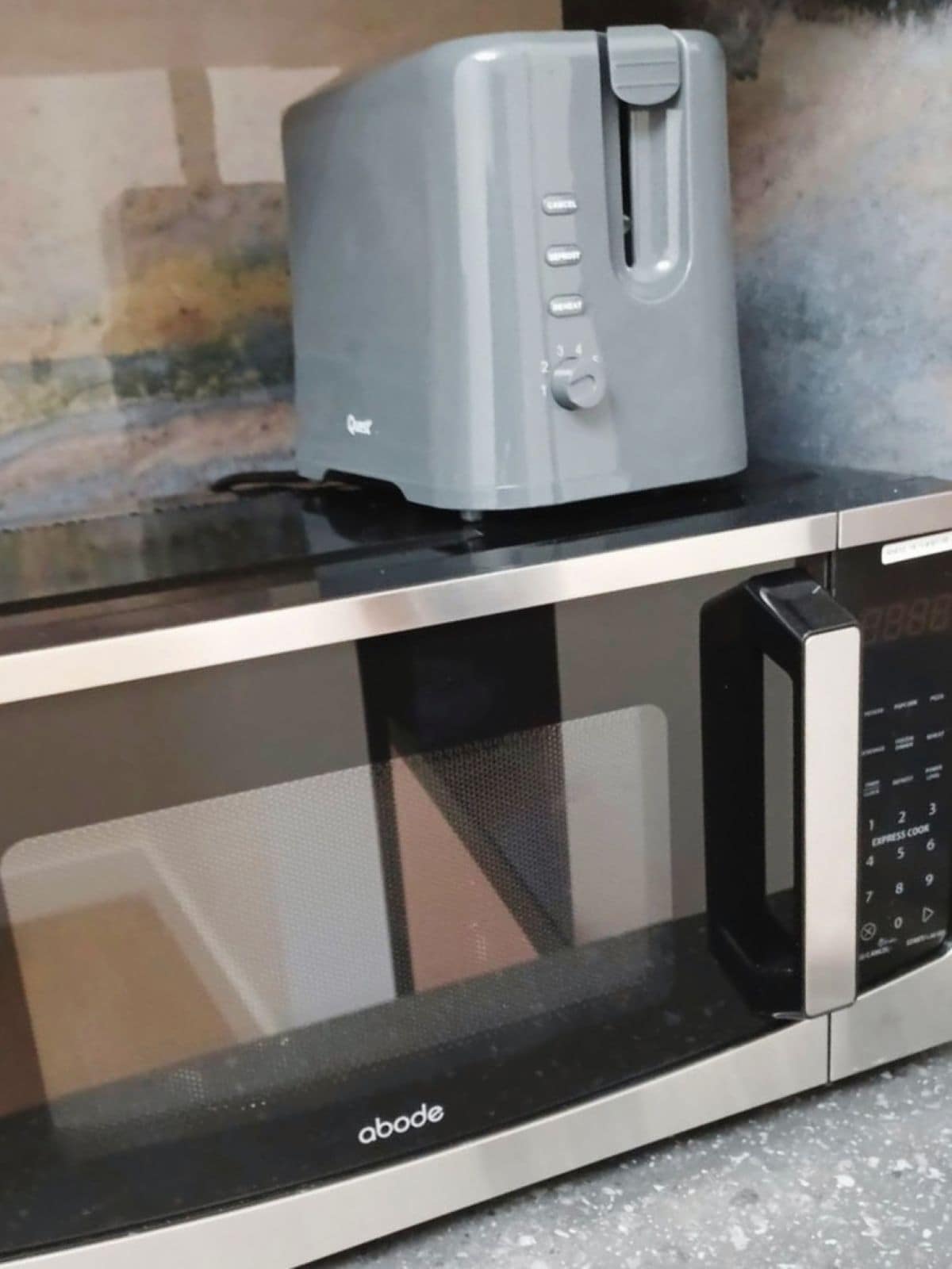 A kitchen with a toaster on top of a microwave.