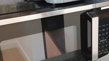 A kitchen with a toaster on top of a microwave.