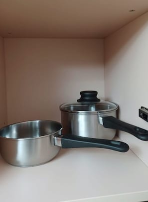 A kitchen with stainless steel cookware, including a pan and a pot with a lid. - International House by Viridian Apartments (London)
