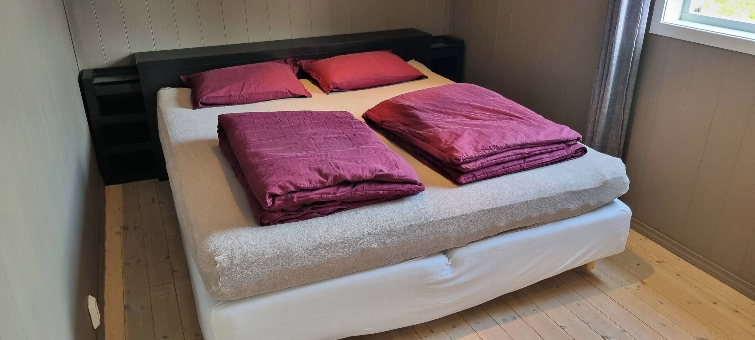 A bed with a headboard, pillows, and a mattress.