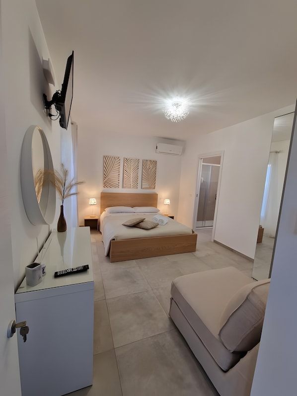 A modern bedroom with a bed, bedside tables, a mirror, and a wardrobe. - Room '1 - Villa Fragi' with Mountain View, Wi-Fi and Air Conditioning (Cinisi)