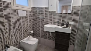 A modern bathroom with a bidet, a sink, and a mirror. - Room '2 - Villa Fragi' with Mountain View, Wi-Fi and Air Conditioning (Cinisi)