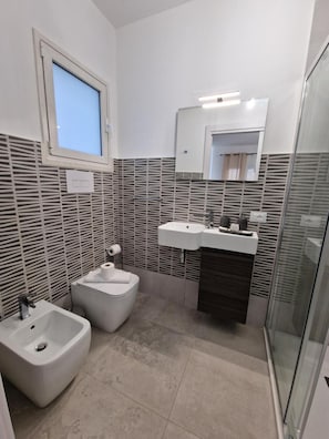 A modern bathroom with a bidet, a sink, and a mirror. - Room '2 - Villa Fragi' with Mountain View, Wi-Fi and Air Conditioning (Cinisi)