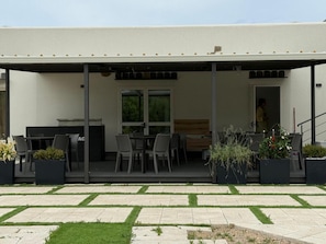 A covered outdoor patio with a dining area, a grill, and potted plants. - Room '2 - Villa Fragi' with Mountain View, Wi-Fi and Air Conditioning (Cinisi)