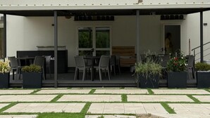 A covered outdoor patio with a dining area, a grill, and potted plants. - Room '3 - Villa Fragi' with Mountain View, Wi-Fi and Air Conditioning (Cinisi)