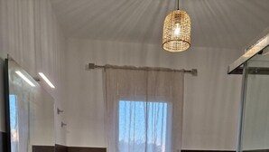 A modern bathroom with a large mirror, a white sink, a glass shower enclosure, and a hanging light fixture. - Room '3 - Villa Fragi' with Mountain View, Wi-Fi and Air Conditioning (Cinisi)