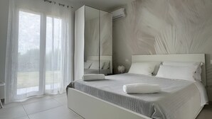 A modern bedroom with a large bed, a mirror, and a view of the outdoors. - Room '5 - Villa Fragi' with Mountain View, Wi-Fi and Air Conditioning (Cinisi)