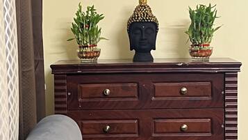 Une commode en bois avec de nombreux tiroirs et deux plantes en pot posées sur le dessus.