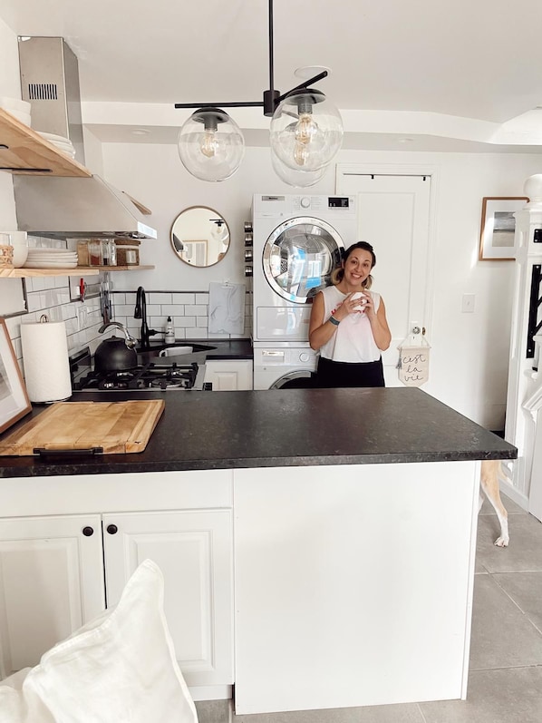 A modern kitchen with a central island, a built-in oven, and a washing machine. - Cozy 2-bedroom Beach Bungalow in lovely Ocean Grove, NJ with AC (Neptune Township)
