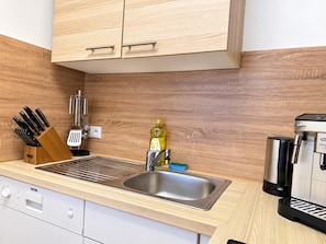 Una cocina moderna con armarios de madera, electrodomésticos de acero inoxidable y un lavamanos integrado.