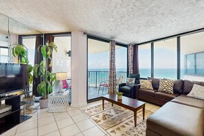 Un salon avec une télévision, un canapé, une table basse et des plantes en pot.